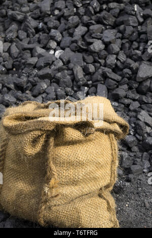 Sac de charbon isolé en plein air sur un sol noir poussiéreux, fond de tas de charbon lâche. Œuvres de la collierie du Musée du pays noir. Exploitation minière de charbon britannique vintage. Banque D'Images