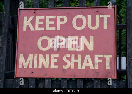 Panneau d'avertissement public « Keep Out Open Mine Shaft » pour les touristes au Black Country Living Museum, Dudley, Royaume-Uni, qui visite le site de la mine de charbon ancienne. Banque D'Images