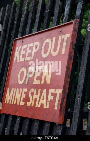 Panneau d'avertissement public « Keep Out Open Mine Shaft » pour les touristes au Black Country Living Museum, Dudley, Royaume-Uni, qui visite le site de la mine de charbon ancienne. Banque D'Images