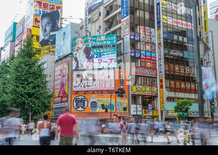 Motion blurred personnes marchant le long des magasins et les panneaux colorés à Akihabara Electric Town. Tokyo, Japon Banque D'Images