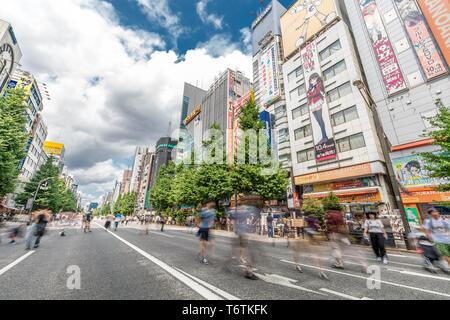 Motion blurred personnes marchant le long des magasins et les panneaux colorés à Akihabara Electric Town. Tokyo, Japon Banque D'Images