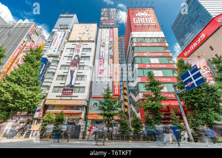 Motion blurred personnes marchant le long des magasins et les panneaux colorés à Akihabara Electric Town. Tokyo, Japon Banque D'Images