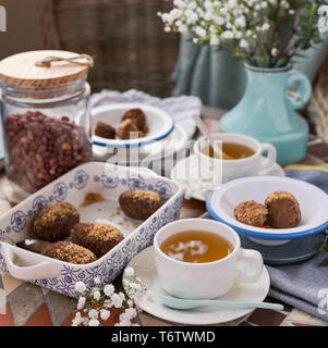 Gâteau traditionnel russe avec le cacao en forme de boule. Table de petit-déjeuner servi avec des tasses de thé et un dessert Banque D'Images