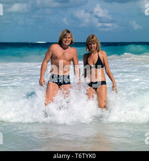 Acteurs et Actrices Volker Lechtenbrink Der Deutsche posiert senneur mit Meer im damaligen Freundin während Sie von Wellen getroffen werden, 1970er. L'acteur allemand Volker Lechtenbrink pose avec son ancienne amie dans la mer alors qu'ils sont frappés par les vagues, 1970. Banque D'Images