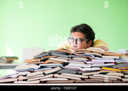 Étudiant avec trop de livres à lire avant l'examen Banque D'Images