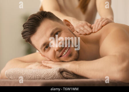 Jeune homme recevant de massage au spa salon Banque D'Images