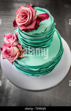 Deux niveaux de fondant gâteau décoré avec des roses. Vue d'en haut. Banque D'Images