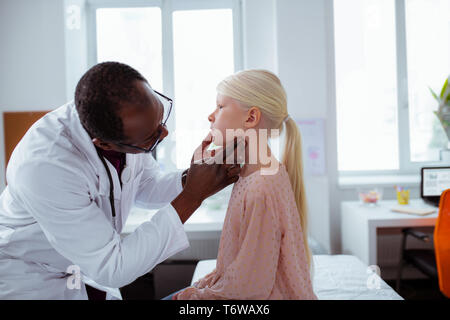 Dark-skinned woman white coat à la fille de la gorge au Banque D'Images