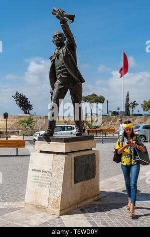 Une femme colorée est plus intéressée par son téléphone que le Monument de 1976 d'Anton Agius à Manwel Dimech, le socialiste maltais, sur la place Castille, Banque D'Images