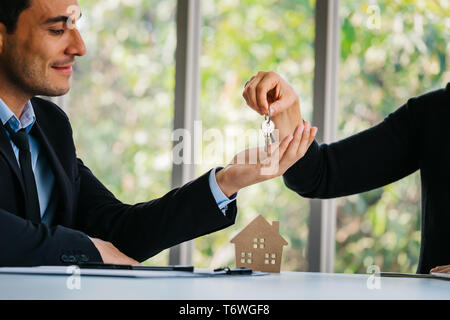 Pour donner l'agent adultes souriants et heureux homme d'affaires tout en restant assis à la maison modèle de l'office de tourisme Agence immobilière Banque D'Images