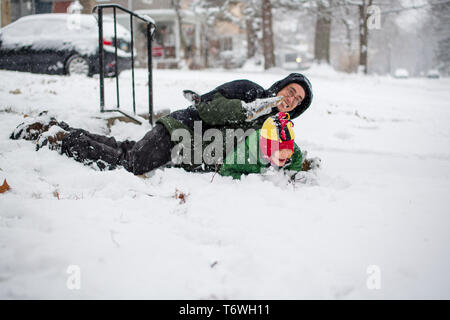Un père et son fils se débattre ensemble dans la neige Banque D'Images