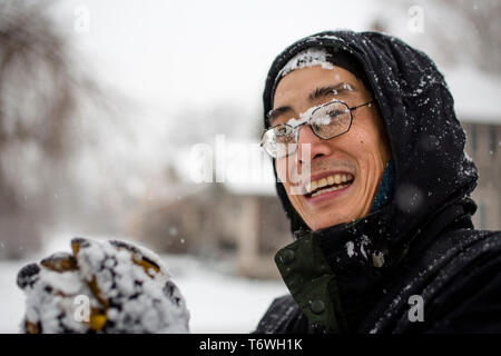 Portrait of a smiling man couverte de neige dans une tempête de neige Banque D'Images