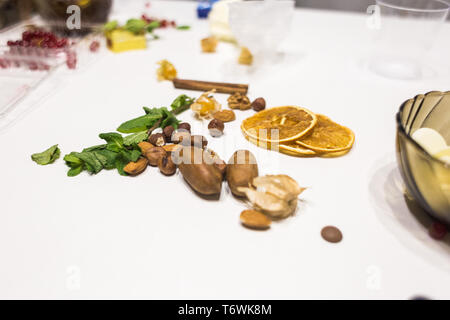 La menthe, les noix, la cannelle et oranges séchées se trouvent sur un tableau blanc dans la cuisine. Banque D'Images