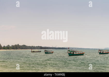 Sihanoukville, Cambodge - 15 mars 2019 : Les petits bateaux de pêche en bois off Ocheuteal Beach. Horizon formé par la jungle de la végétation sur la rive. Banque D'Images