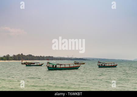 Sihanoukville, Cambodge - Mars 15, 2019 : des petits bateaux de pêche en bois off Ocheuteal Beach. Horizon formé par la jungle de la végétation sur la rive. Banque D'Images