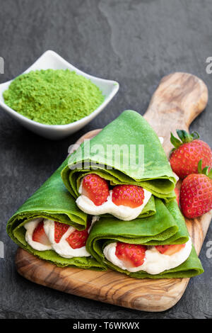 Thé vert matcha la crêpe de crème fouettée et de fraises sur le service à bord Banque D'Images