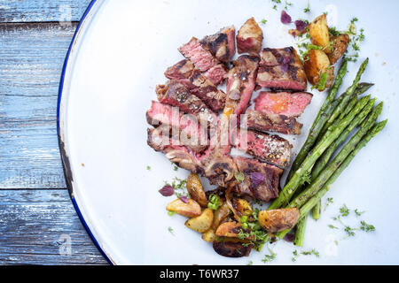 Sec Barbecue steak d'aloyau de wagyu de meubles aux asperges vertes et pommes de terre rissolées en vue de dessus sur une plaque Banque D'Images