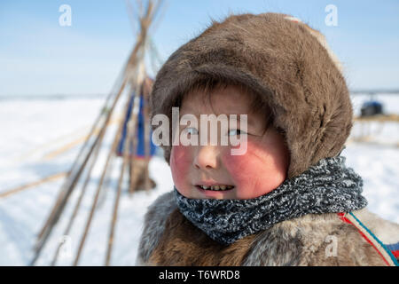 La Russie, dans la région autonome de Yamal-Nenets, péninsule de Yamal. Camp de nomades éleveurs de rennes Nenets, jeune enfant en tenue traditionnelle. Banque D'Images