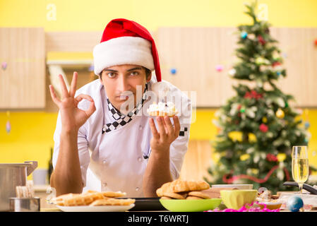 Jeune chef mari travaillant en cuisine à la veille de Noël Banque D'Images