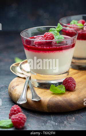 Panacotta vanille avec sauce aux baies et framboise. Banque D'Images