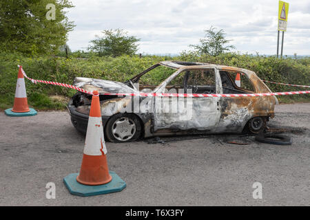 Voiture brûlée abandonnés dans un coin de campagne location Park, Royaume-Uni Banque D'Images