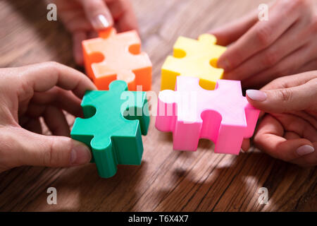 Close-up of young Puzzle résoudre ensemble sur un bureau en bois Banque D'Images