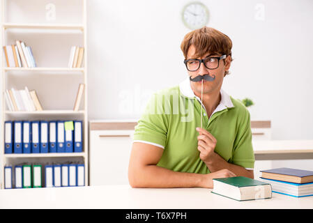 Étudiant avec fake moustache reading book Banque D'Images