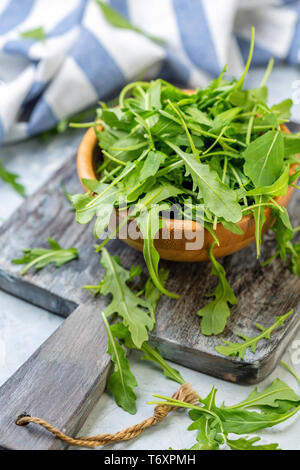 Feuilles de roquette dans un bol en bois. Banque D'Images