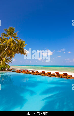 Piscine et des chaises longues sur la plage aux Maldives Banque D'Images