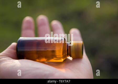 Bouteille de pharmacie, l'extrait d'herbe. Remède Naturel sur la paume de votre main. Banque D'Images