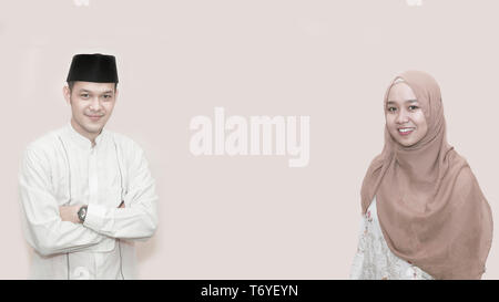 Portrait of young Asian Muslim man and woman smiling en face de la caméra à l'aide de peci ou creux avec copie espace prêt à l'emploi - droit Banque D'Images