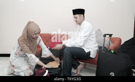 Heureux couple musulman homme et femme mettre ses affaires dans la valise avec une assurance préparer voyagent pour le ramadan moubarak eid celebration -droit Banque D'Images