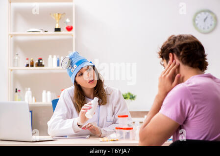 Jeune homme séduisant jeune femme médecin oto-rhino-laryngologiste visite Banque D'Images