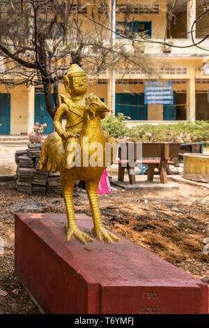 Sihanoukville, Cambodge - Mars 15, 2019 : Phsar Leu école élémentaire. Closeup portrait of statue en or de l'année de Coq, avec figure bouddhiste sur un Banque D'Images