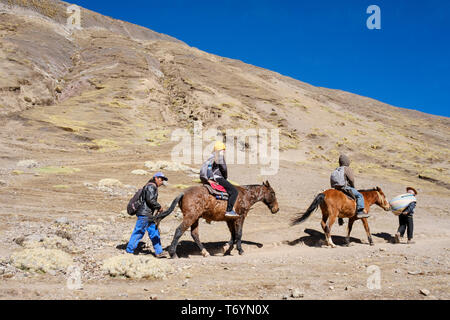 Les touristes à cheval pour se rendre à l'impressionnante Montagne Arc-en-ciel en Los Andes du Pérou Banque D'Images