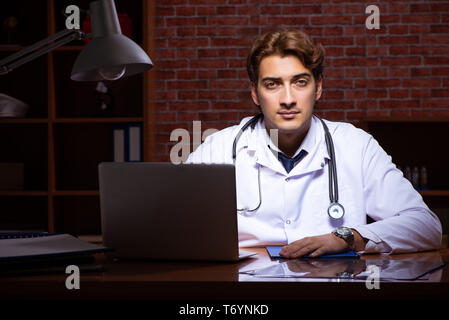 Beau jeune médecin travaillant la nuit à l'hôpital Banque D'Images