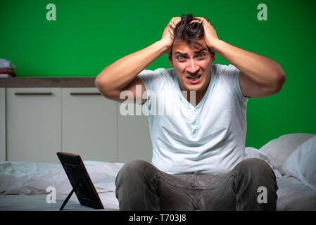 Beau jeune homme souffrant d'amour dans la chambre à coucher Banque D'Images