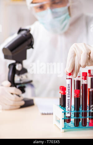 Beau jeune assistant de laboratoire à l'essai des échantillons de sang à l'hôpital Banque D'Images