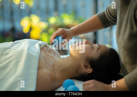 Jeune femme reçoit en cornet de rajeunissement du visage massage du visage à l'acupuncture traitement wellness spa Banque D'Images