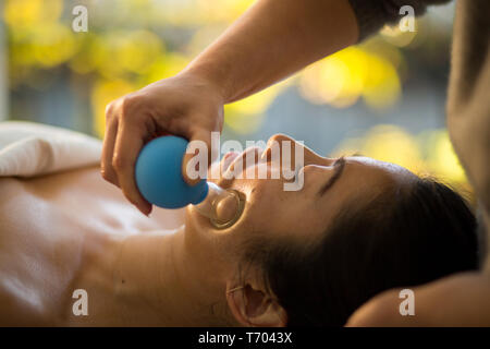 Jeune femme reçoit en cornet de rajeunissement du visage massage du visage à l'acupuncture traitement wellness spa Banque D'Images