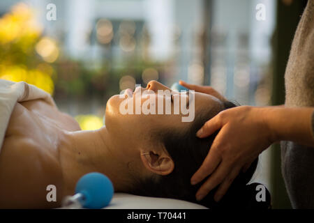 Jeune femme reçoit en cornet de rajeunissement du visage massage du visage à l'acupuncture traitement wellness spa Banque D'Images