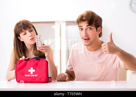 Jeune famille obtenir un traitement avec trousse de premiers secours Banque D'Images