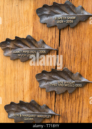 Pilier en bois de chêne avec des plaques en forme de feuilles de chêne inscrit de souvenir dans Bradgate Park Memorial Bois, Leicestershire, Angleterre, Royaume-Uni. Banque D'Images