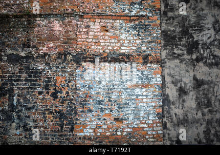 Vieux Mur de brique sur le côté d'un bâtiment démoli révélant la vieille peinture et enduit. Super pour un fond grunge. Banque D'Images