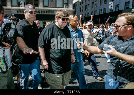 Réalisatrice de documentaires et auteur Michael Moore est escorté par des gardes du corps alors qu'il participait à une marche de protestation au cours de la Convention nationale du parti républicain à New York. À la gauche de Moore, choc jock et théoricien de la conspiration Alex Jones tente d'interviewer Moore. Banque D'Images