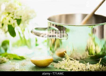 Close up of elderflowers, citron et du sucre sur table de cuisine avec marmite. Sirop de sureau fait maison ou faire de la confiture. Des fleurs plus sain preparati Banque D'Images