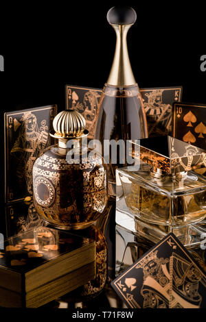 Composition du parfum des femmes de luxe et de cartes à jouer avec la réflexion sur un fond noir Banque D'Images