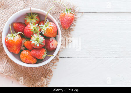 Dans un bol de fraises fraîches sur fond de bois Banque D'Images