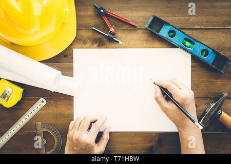 Travailler avec l'architecte construction tools et casques de sécurité sur fond de bois Banque D'Images