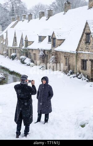 Prendre des photos et marcher Toursits arounbd le Village de Bibury et la rangée de maisons en rangée knwon Arlington, photographié ici dans une neige de janvier. Banque D'Images